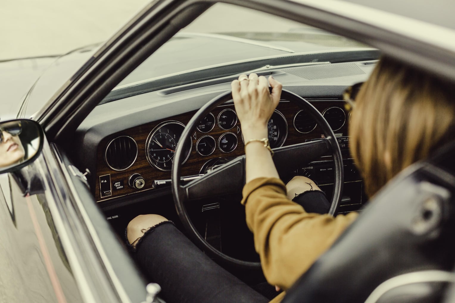 woman driving a gray car on the road wear tan shirt