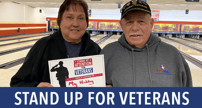two members standing in front of the bowling lane
